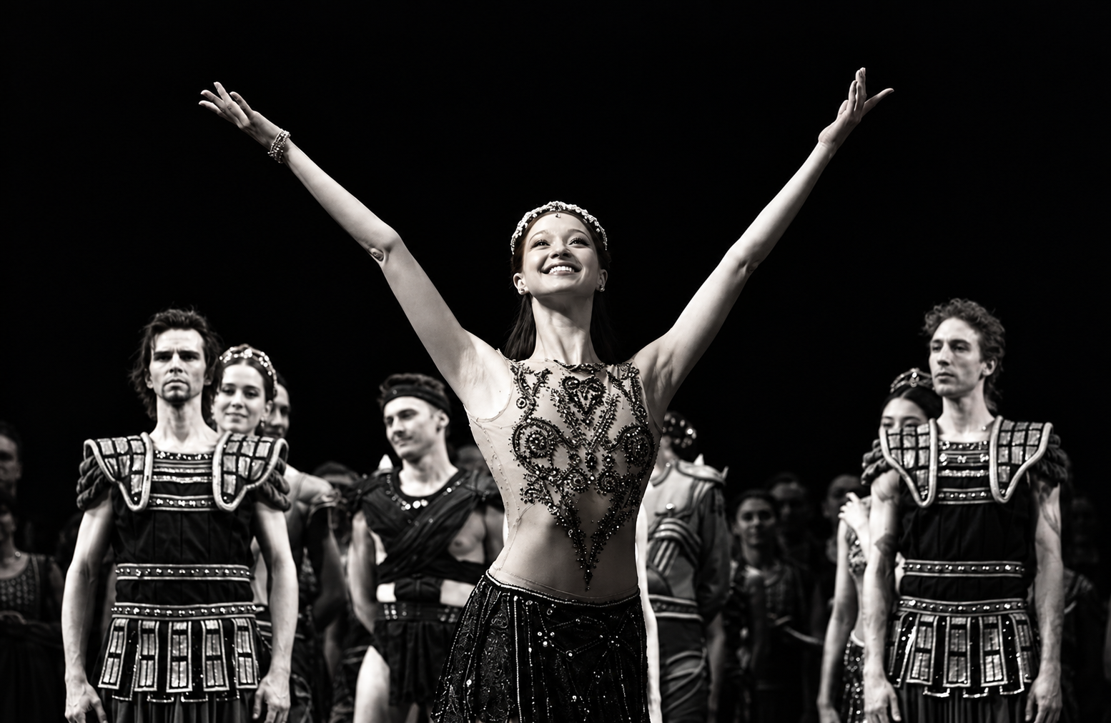 Nina Osman in Spartacus, arms raised, with the company behind her